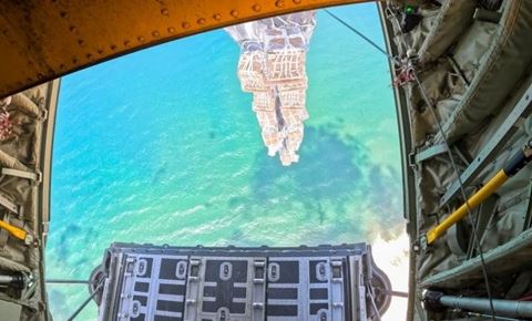 De tyve tons gods forlader flyet over Gaza. Vinklen på billedet snyder lidt. Droppet foregår meget tæt på vandkanten. Godset falder langsomt mod sandet på stranden. Foto: Rune Dyrholm / Forsvaret 