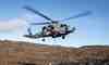 En Seahawk-helikopter hoister materiel fra inspektionsskibet Vædderen ind på landjorden, hvor Beredskabsstyrelsen bygger lejr til brug under øvelsen. Foto: Stine Holbech, Forsvaret.